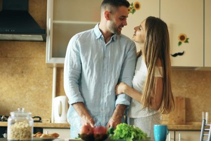 Portrait of loving couple cooking breakfast smiling in the kitchen at home